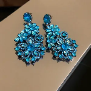 Exaggerated blue crystal flower drop earrings with a vintage silver needle design