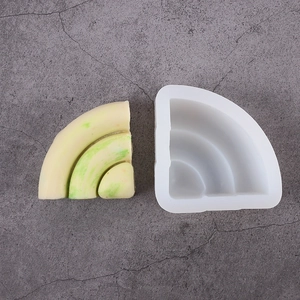 Detail of fan-shaped silicone waffle mold with yellow resin craft display on grey surface