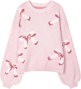 Detail of pink knit sweater showing red and white bow jacquard pattern and soft texture