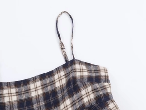 Macro view of thin straps and textured plaid fabric in blue and beige tones