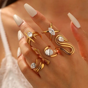 Five-piece set of gold-plated irregular zircon rings on model's hand with warm lighting