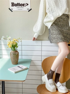 Detail of crew socks with white heart embroidery paired with platform loafers and skirt