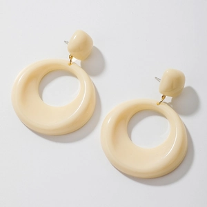 Detailed view of cream acrylic geometric hoop earrings with polished glossy surface finish