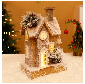 Detail of wooden Christmas house ornament with warm LED lights and artificial snow texture