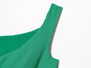 Detailed macro view showing the green linen blend fabric texture and neckline strap