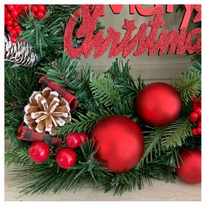 Makroaufnahme von Weihnachtskranz mit roten Beeren, Zapfen und Merry Christmas Schild