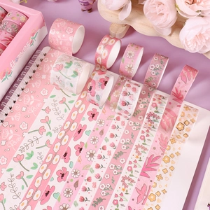 Detailed view of pink floral washi tape rolls displayed on a journal for DIY crafts.
