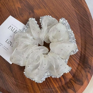 Detail of cream organza hair scrunchie with micro-set pearls and silver rhinestones
