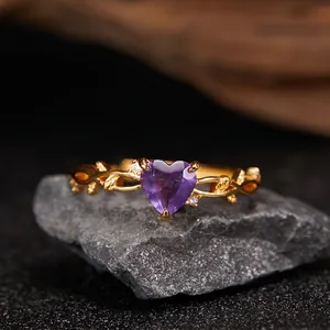 Macro detail of heart-shaped purple amethyst and gold vine design on a S925 silver ring