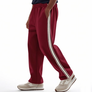 Detail of burgundy sports pants with contrasting side stripes and smooth knit texture