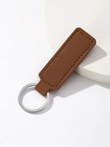 Detail shot of brown PU leather keychain featuring silver ring and fine stitching detail
