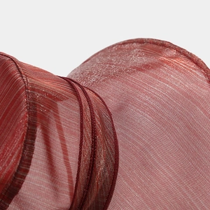 Détail macro du tissu en organza rouge translucide avec des fils d'argent scintillants
