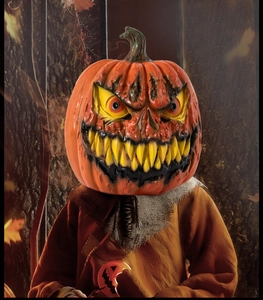 Detailed view of scary Halloween pumpkin head mask with tattered burlap costume in misty forest