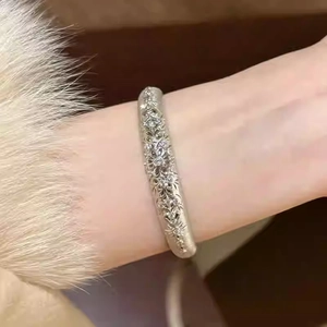 Macro shot of vintage silver bracelet with etched flower patterns and sparkling zircons