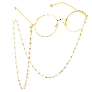 Close-up of gold metal round glasses frame with elegant pearl and gold bead eyewear chain