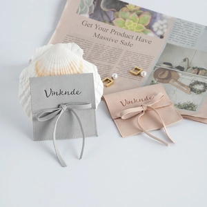 Detail of microfiber suede jewelry pouches in grey and nude pink with ribbon bows