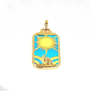 Detailed shot of gold tarot sun pendant with sky blue enamel and yellow sun rays