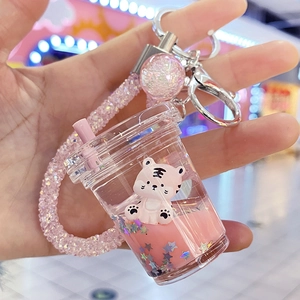 Detail of pink tiger milk tea keychain with flowing liquid and star sequins charms