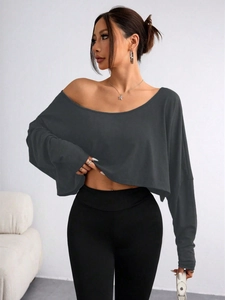 Detail of loose fit dark grey off-shoulder top showing soft fabric drape on the sleeve