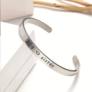 Macro shot of silver stainless steel cuff bracelet with big sister engraving