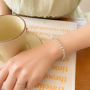 Elegant 925 sterling silver 2mm bead bracelet with diamond accent ring on female wrist