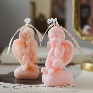 Pink cherub angel scented candles with cream ribbon decoration on a vintage backdrop