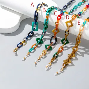 Colorful acrylic geometric link eyeglass chains with gold clasps shown on white pedestals