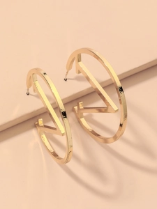 Detail of a gold geometric circle earring featuring a unique Z-shaped internal design