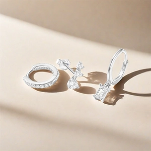 Close-up of 925 silver earring set with pave zircon and rectangle pendant on beige base