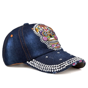 Detail of distressed denim baseball cap with rhinestone sugar skull embroidery and sequins