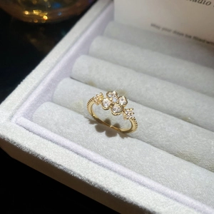 Detail of gold flower ring with clover heart zircons and micro-beaded band finish