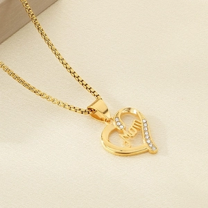 Macro detail of gold hollow heart pendant with Mom lettering and sparkling zircons