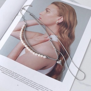Macro view of freshwater pearl and chain link necklace with polished heart pendant detail