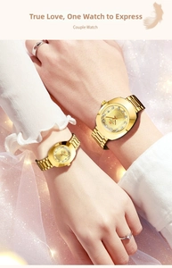 Close-up of golden couple watches with diamond scales on wrists with soft bokeh background