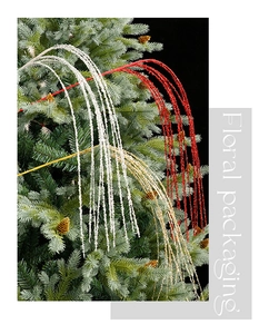 Close-up of glitter willow spray in red gold and white on a pine Christmas tree