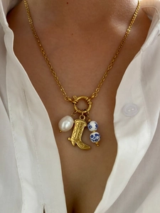 Detail of necklace with white freshwater pearl, golden boot pendant and porcelain beads