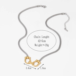 Detail of mixed-metal necklace showing silver snake chain with golden horsebit pendant