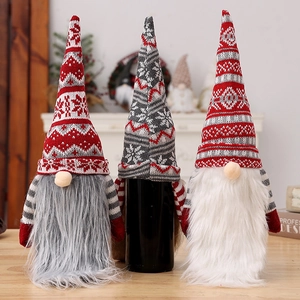 Three knitted Christmas gnome wine bottle covers in red and grey festive patterns