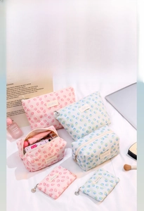 Detail of floral makeup bag with lace texture, golden shell zipper and spacious interior