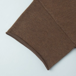 Gros plan sur la texture en tricot marron avec coutures fines et bord à ourlet roulé