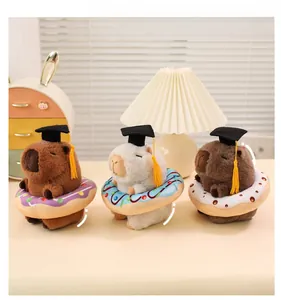 Capybara plush dolls in graduation caps with colorful donut rings on a desk display
