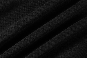 Detailed macro view of black knitted fabric texture with professional shadow depth