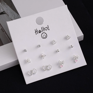 Close-up of 12-piece silver stud earring set with cherry, bow, and heart designs