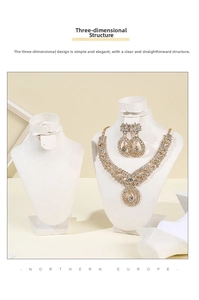 Detailed view of luxury gold bridal jewelry set on a white velvet bust mannequin display
