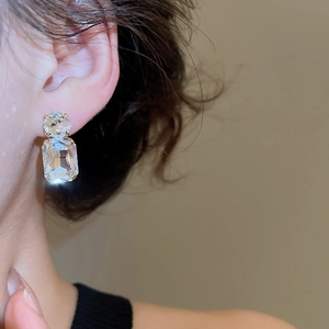 Close-up of elegant geometric crystal earrings with round and rectangular diamond studs