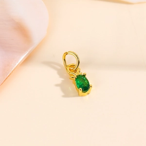 Detailed close-up of a 18k gold plated pineapple pendant with a sparkling green zircon