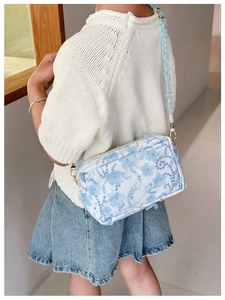 Detailed side view of floral girl's crossbody bag with 3D fabric flower and sequin patterns