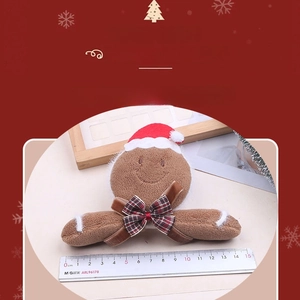 Detailed view of 14cm plush gingerbread man with Christmas hat and plaid bow accessory