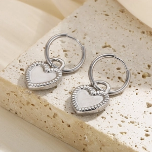 Macro shot of S925 sterling silver heart hoop earrings on natural stone