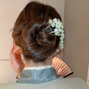 Details einer Schmetterlings-Haarnadel mit Perlen-Quasten und grünen Perlen